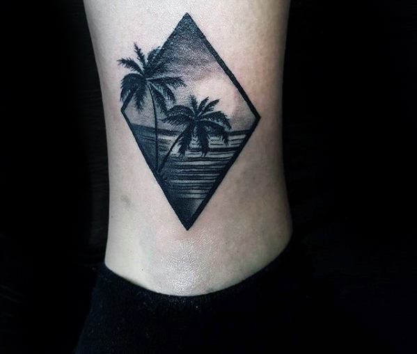 Tatuaje de tobillo silueta de palmera en la playa