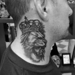 Tatuaje de león en el cuello con corona