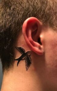 Tatuaje de ave detrás de la oreja hombre
