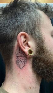 Tatuaje de cara tribal detrás de la oreja hombre