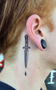 Tatuaje de cuchillo detrás de la oreja hombre