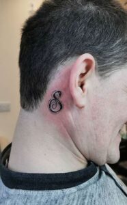 Tatuaje de letra detrás de la oreja hombre