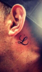 Tatuaje de letra l detrás de la oreja hombre