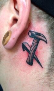 Tatuaje de martillo detrás de la oreja hombre