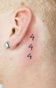 Tatuaje de numeros detrás de la oreja hombre