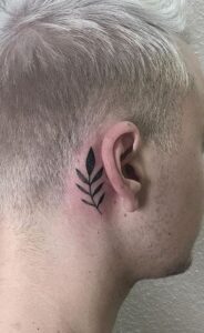 Tatuaje de rama detrás de la oreja hombre